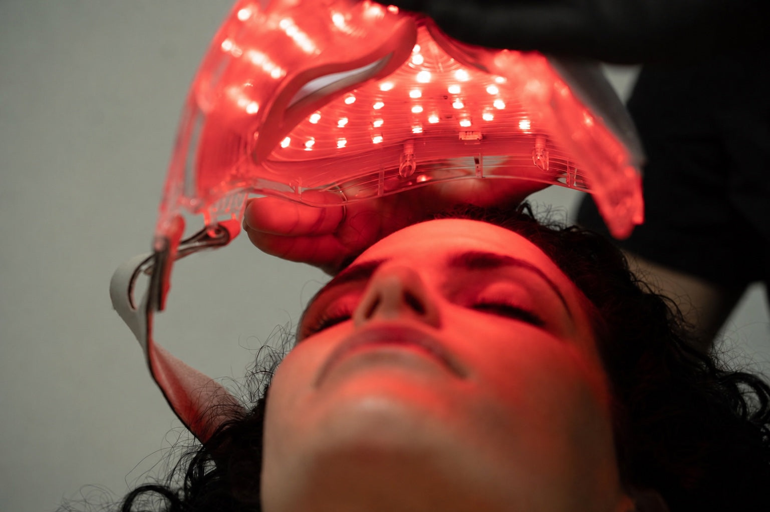 Woman using the LUMÉA Pro red LED face mask